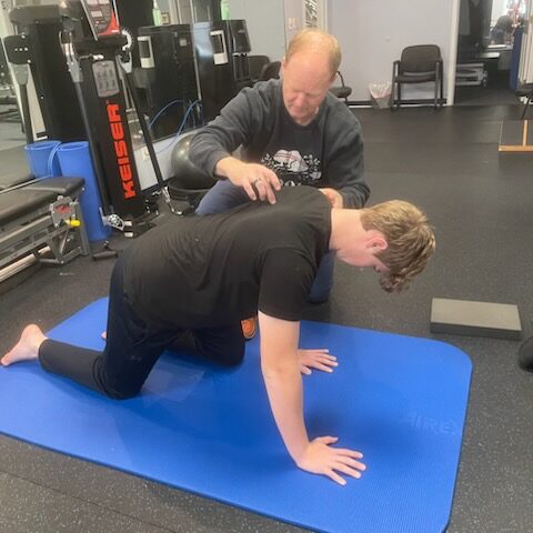 Miami Athletic Club chiropractor adjusting a kneeling man's neck