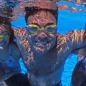 Miami Athletic Club 2 men and 2 women underwater, wearing goggles at pool