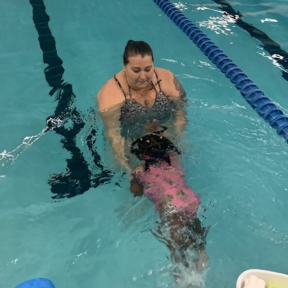 Miami Athletic Club woman teaching a young girl to swim