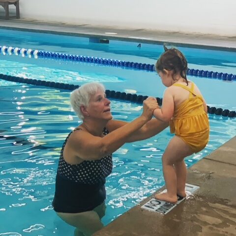 Miami Athletic Club swim instructor helping a toddler jump in the pool