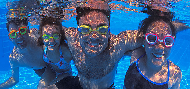 Miami Athletic Club 2 men and 2 women underwater, wearing goggles at pool